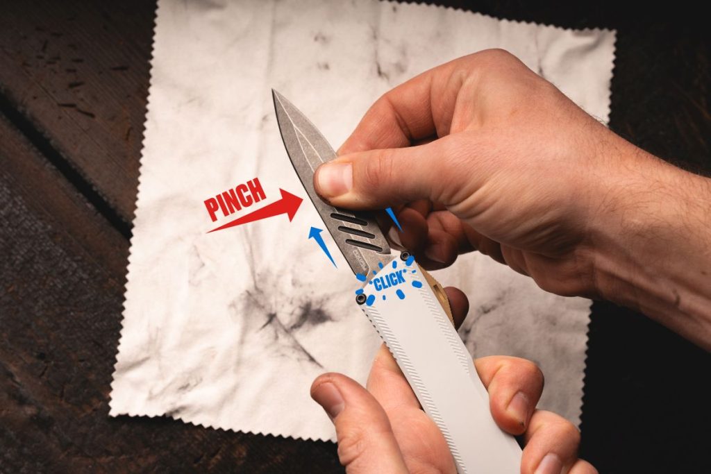 A man pinching the blade of an OTF knife and pulling it out, causing it to click back into place.