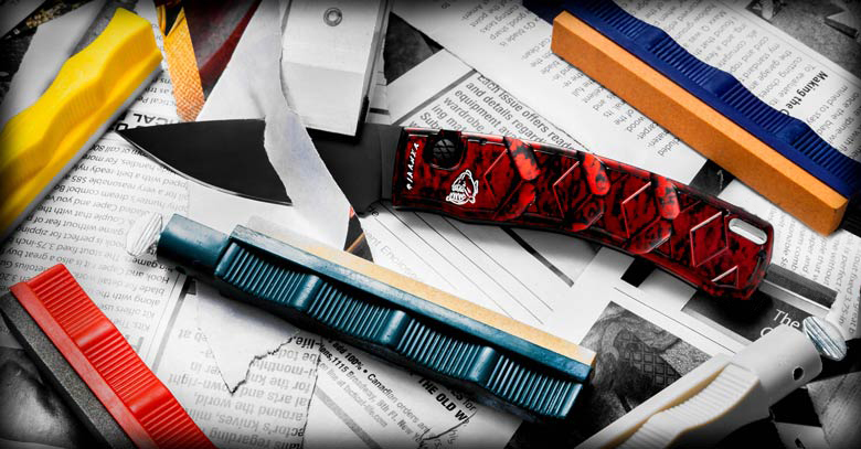 A red knife cutting paper beside sharpening stones.
