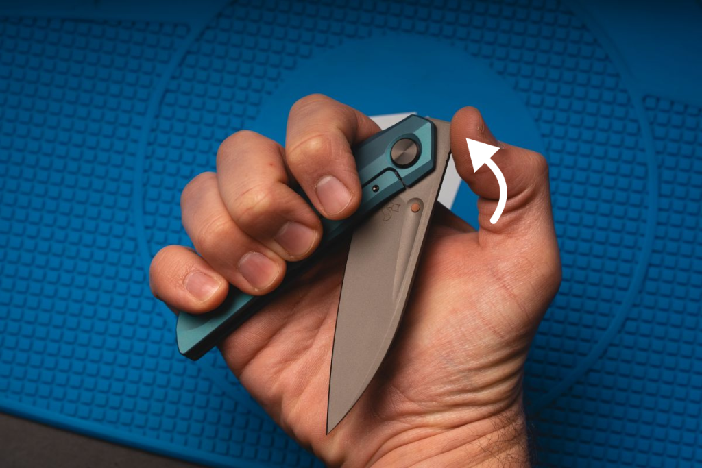 A man using the front flipper opener on a blue Reate knife.