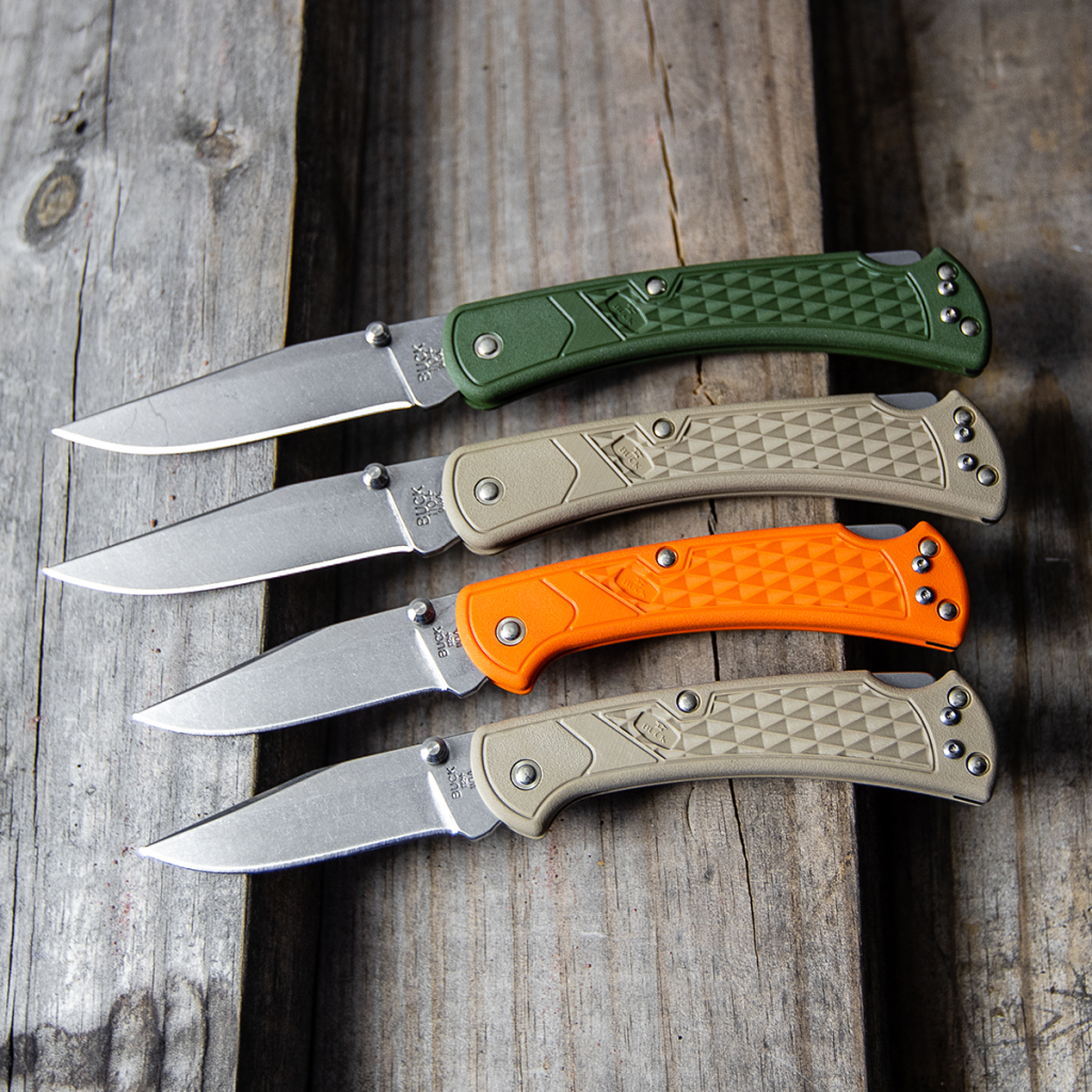 Buck 110 slim in green and tan next to the Buck 112 slim in orange and tan.