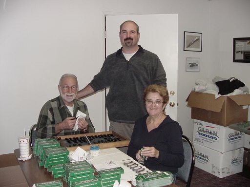 Dave Wattenberg and his parents assembling knives on a kitchen table
