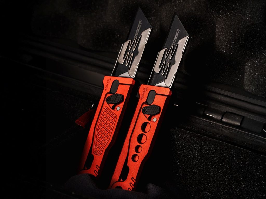 Two red Reate EXO-U's displayed in a knife case.