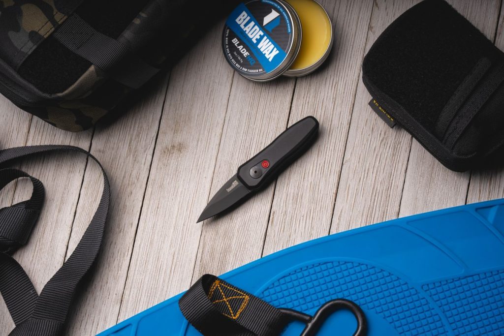 A black Kershaw Launch 4 with a black blade and black handle on a pale table.
