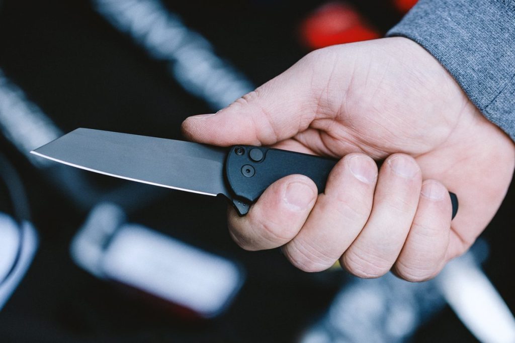 A black Pro-Tech Malibu in a man's hand.