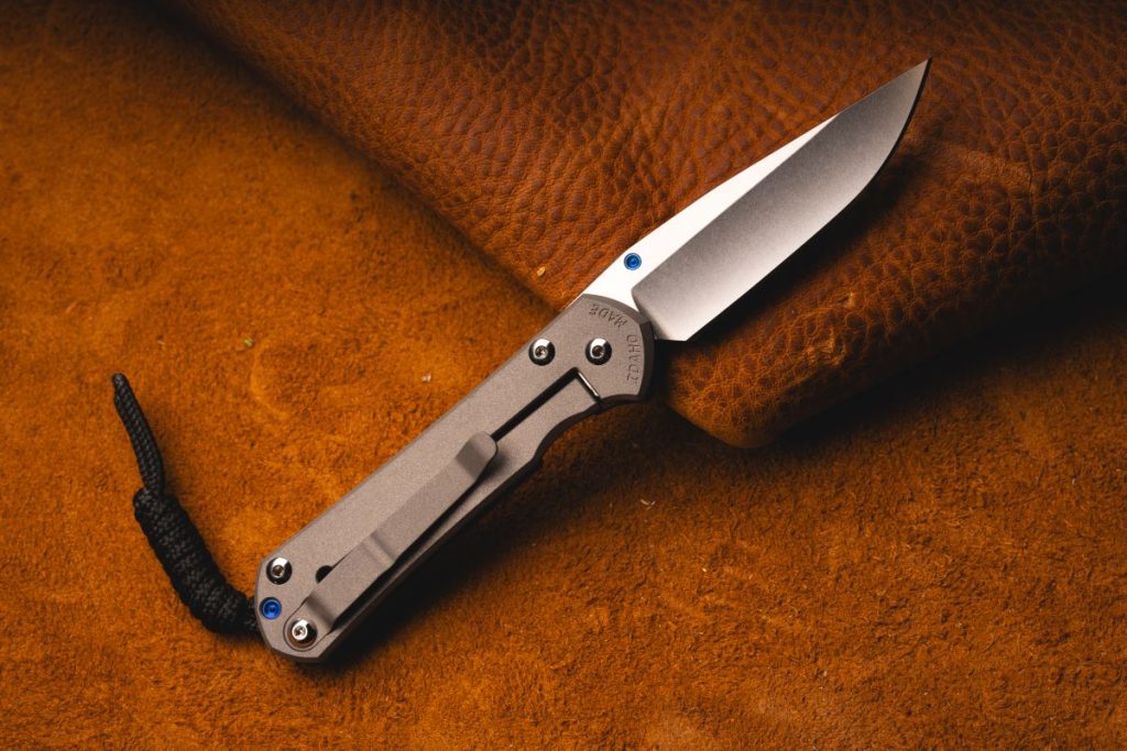 A Chris Reeve Small Sebenza 31 on a leather background. Its frame lock is prominently featured.
