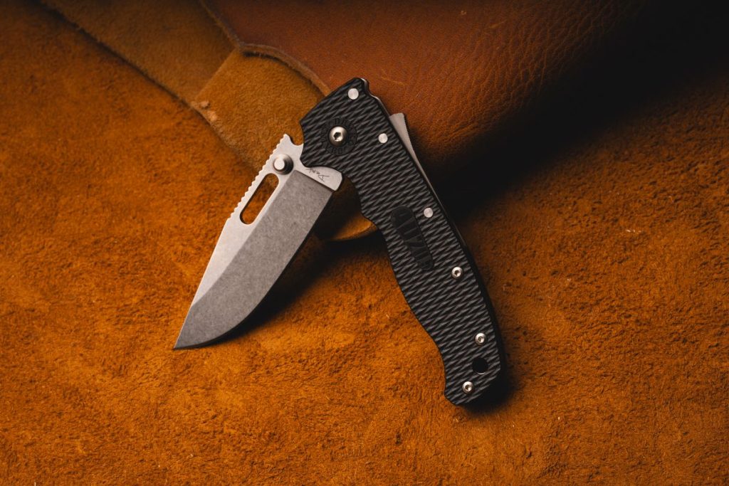 A Demko AD-20.5 pocket knife on a leather mat, Shock-Lock displayed.