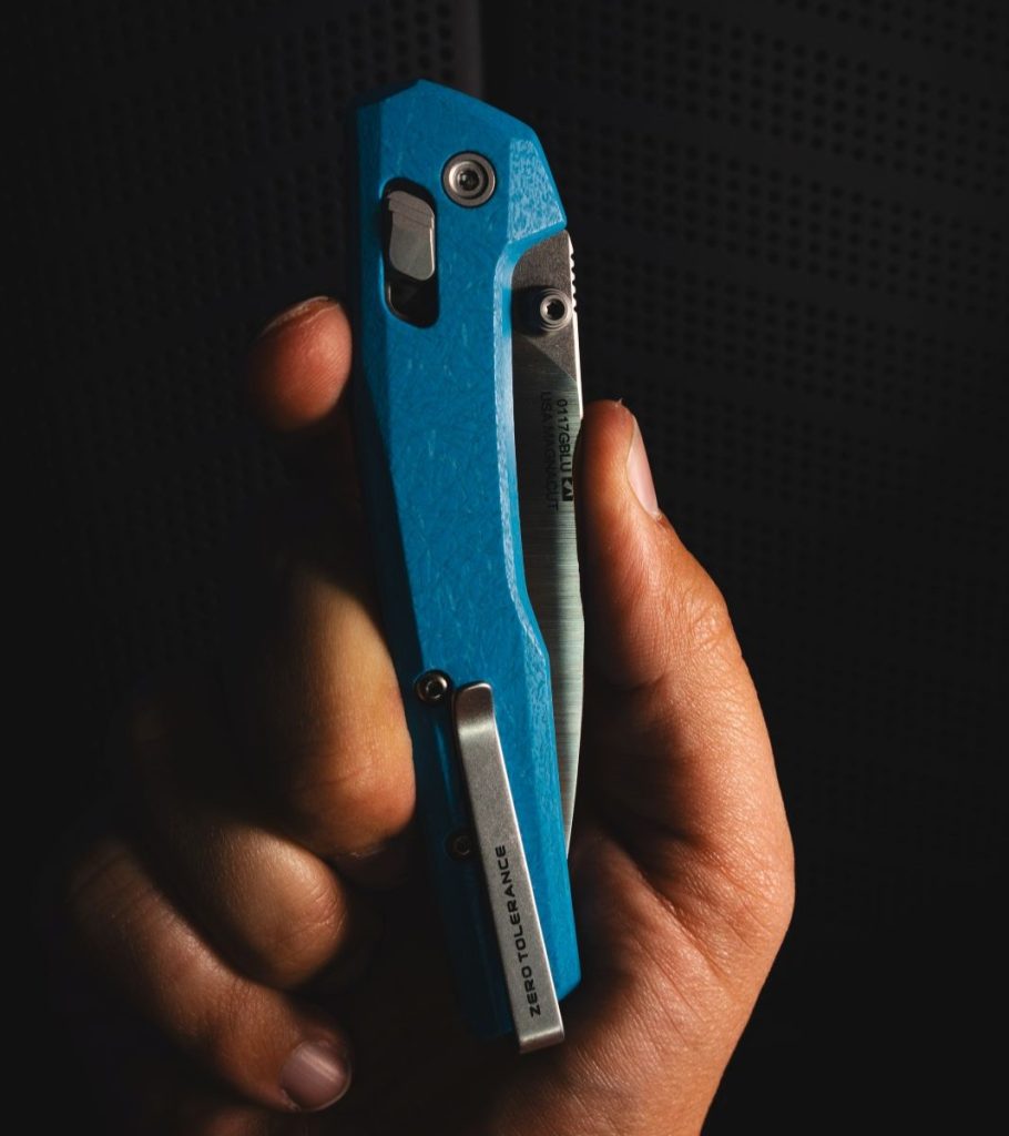 The Blade HQ exclusive ZT 0117GBLU in a man's hand, closed, clip-side out.