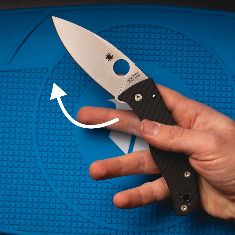 A man holding a Spyderco Bodacious, having just flicked the knife open.