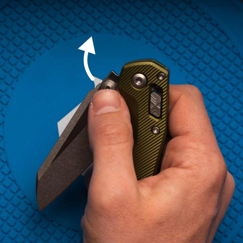 A man using the thumb stud opener on a green Microtech MSI Mini.