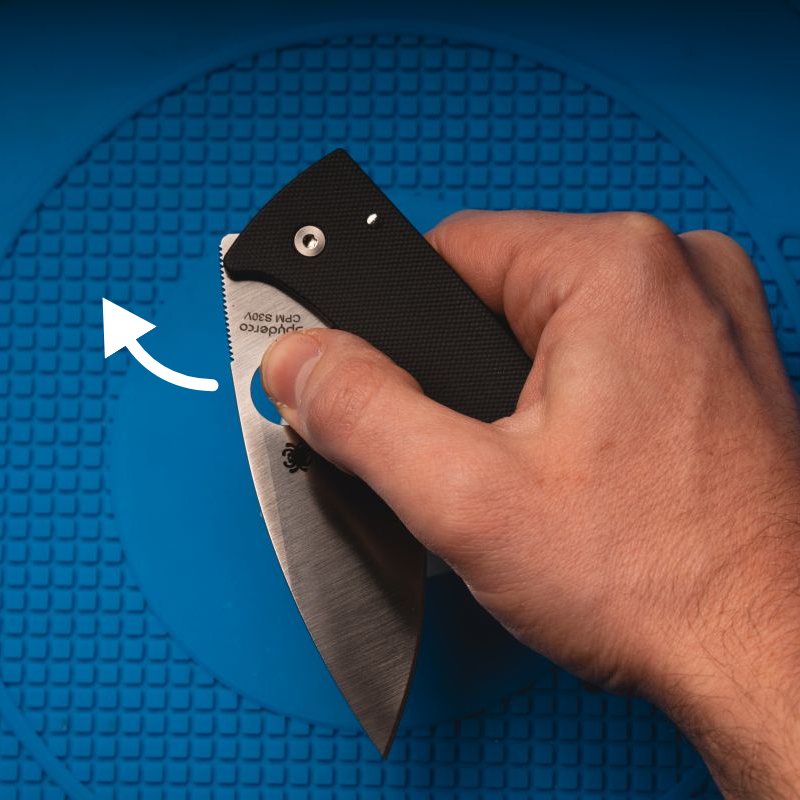 A man using the thumb hole opener on a Spyderco Bodacious.