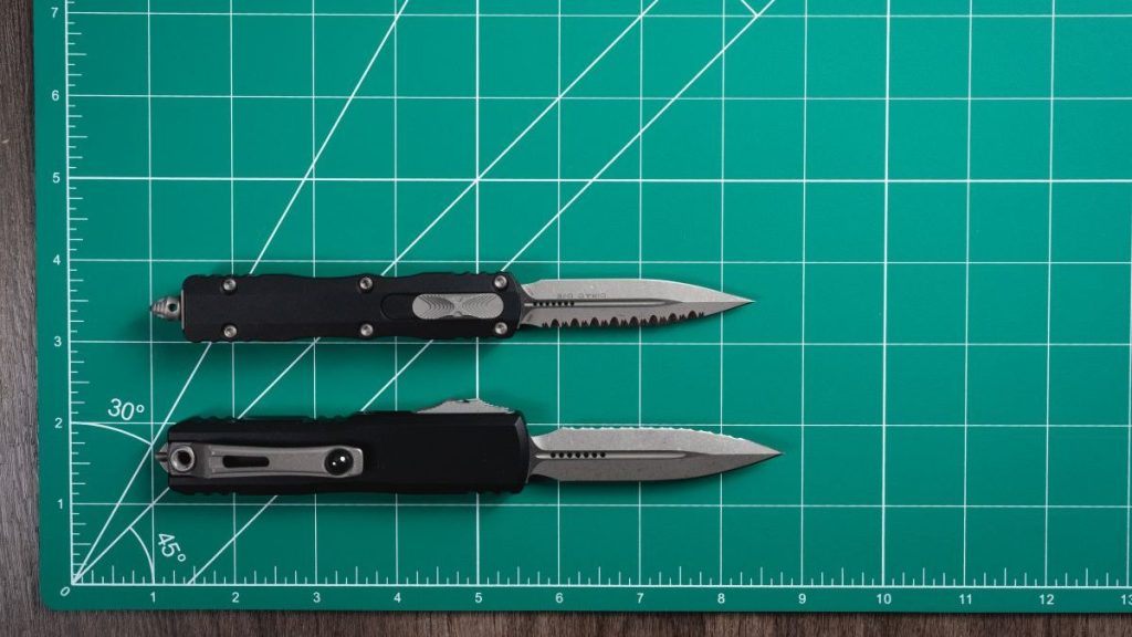All small Microtech OTF knives lined up on a green mat